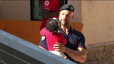 Pasquale, carabinier italien, porte une petite fille somalienne à Lampedusa.