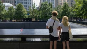 Le 8 septembre 2021, à New York, un jeune couple se tient devant l'un des deux bassins du mémorial du 11-Septembre à la place de tour sud du World Trade Center détruite dans les attentats jihadistes du 11 septembre 2001 dont les Etats-Unis célèbrent samedi le 20e anniversaire