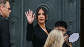La célébrité américaine Kim Kardashian (au centre) salue à son arrivée à la cour d'assises pour le procès au cours duquel elle témoignera sur le vol de 2016 qui l'a vu se faire dépouiller de millions de dollars de bijoux sous la menace d'une arme à Paris, le 13 mai 2025. Le procès de ce vol sensationnel de bijoux de neuf millions d'euros s'est ouvert à Paris le 28 avril 2025.