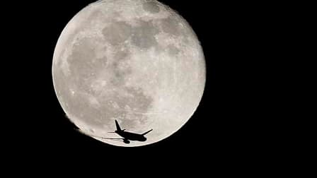 Un avion devant la lune - Image d'illustration
