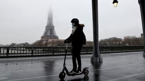 Une femme sur une trottinette électrique près de la Tour Eiffel le 27 janvier 2021.