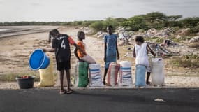 Des jeunes filles vendent des sacs de sel sur le bord de la route à la périphérie de Saint-Louis, le 9 août 2021.