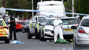 Des officiers de police et du personnel médico-légal se tiennent derrière un cordon sur Hart Street à Southport, dans le nord-ouest de l'Angleterre, le 29 juillet 2024, à la suite d'une attaque au couteau. 