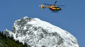 Un hélicoptère du SDIS survole un éboulement à Laruns, près de la frontière espagnole, le 17 mai 2023 dans les Pyrénées-Atlantiques. 