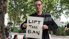 Robert Del Naja, également connu sous le nom de 3D, du groupe Massive Attack, brandit une pancarte "Lift the Ban" (Lève l'interdiction) alors que des centaines de personnes se rassemblent pour participer à une manifestation au Parliament Square contre l'interdiction de Palestine Action à Londres, au Royaume-Uni, le 6 septembre 2025.