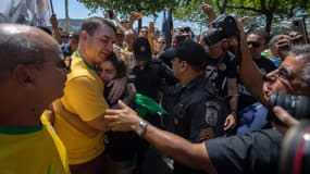 Flavio Bolsonaro, le fils du candidat Jair Bolsonaro, enlace une supportrice de son père lors d'un meeting à Copacabana, à Rio, le 9 septembre.