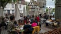 Une serveuse apporte les plats aux clients installés à la terrasse d'un restaurant, le 19 mai 2022 à Strasbourg