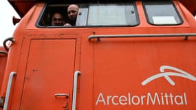 Des ouvriers d'ArcelorMittal observent depuis une locomotive utilisée comme barrière filtrante alors qu'ils participent à une manifestation contre la fermeture de l'usine de Saint-Brice-Courcelles, près de Reims, dans le nord de la France, le 25 novembre 2024.
