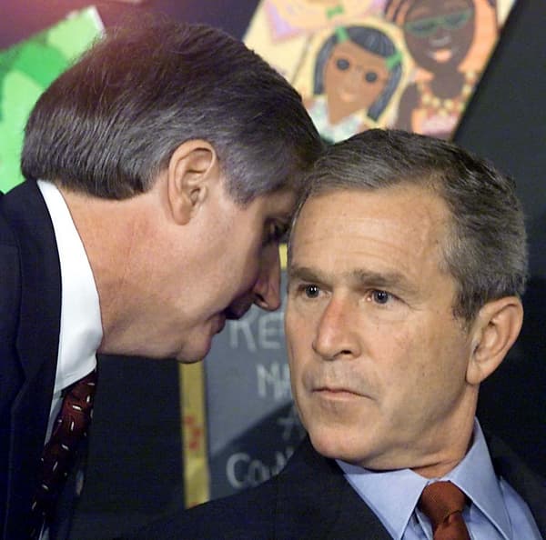George Bush interrompu par son chef de cabinet Andrew Card lui informant du crash des deux avions sur les tours jumelles du World Trade Center, le 11 septembre 2011 en Floride.
