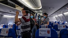 Des passagers masqués à bord d'un avion faisant la liaison entre Wuhan et Shangai le 29 mai 2020.
