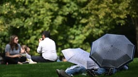 Des personnes s'abritent du soleil sous des parasols en prenant un bain de soleil à St James's Park, dans le centre de Londres, le 6 septembre 2023, alors que la vague de chaleur de la fin de l'été se poursuit.