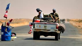Combattants rebelles revenant de la ligne de front près de Ras Lanouf à une centaine de kilomètres à l'est de Syrte. Selon un commandant des rebelles libyens, au moins 10 jours vont être nécessaires pour prendre la ville de Syrte, l'un des derniers bastio