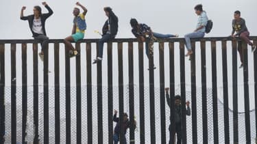 Des migrants qui ont participé à la caravane des migrants escaladent la barrière entre la frontière mexicaine et les Etats-Unis, le 29 avril 2018 à San Ysidro, en Californie