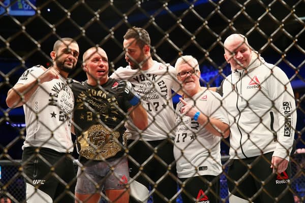 Georges St-Pierre (deuxième en partant de la gauche) entouré par son équipe après avoir remporté le titre des moyens de l'UFC en novembre 2017