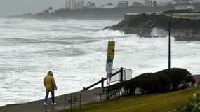 Une personne marche près des fortes vagues causées par le passage de la tempête Ciaran, le long de la plage Milady à Biarritz, dans les Pyrénées-Atlantiques, le 3 novembre 2023