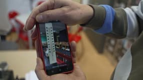 Un professeur montre une photo d'un thermomètre dans une salle de classe. 