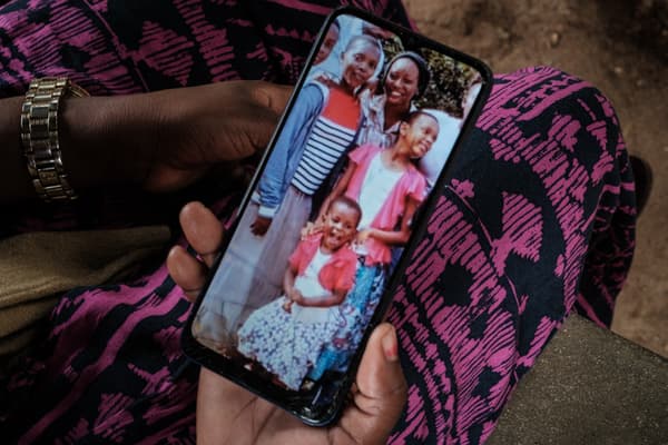 Bethy Kahindi, 37 ans, montre une photo sur son téléphone de trois des six filles de sa sœur de 45 ans alors qu'elle cherche leurs corps à la morgue de l'hôpital de Malindi Sub-County à Malindi, le 26 avril 2023.