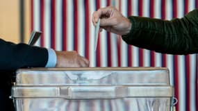 Une personne glisse son bulletin dans l'urne pour la présidentielle française, à Washington, le 9 avril 2022