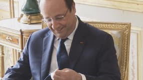 François Hollande à la recheche de la marque de sa cravate.