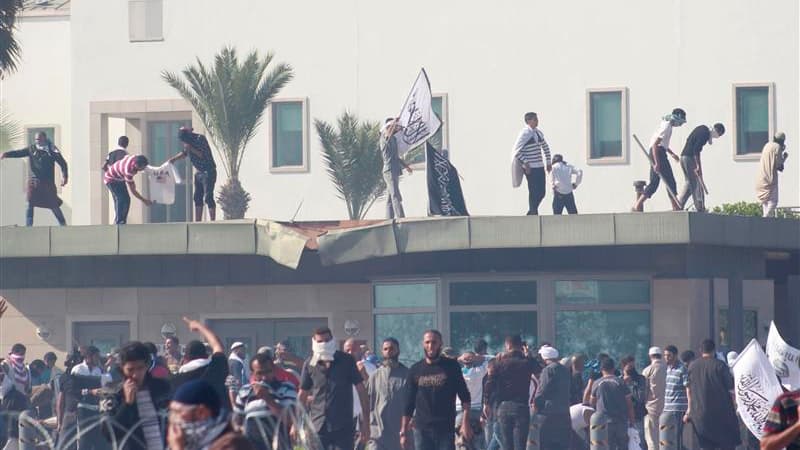 Manifestants sur le toit d'un bâtiment de l'ambassade des Etats-Unis à Tunis. Trois personnes au moins ont été tuées et 28 autres blessées vendredi à Tunis lors d'affrontements avec la police tunisienne aux abords et à l'intérieur de l'ambassade américain