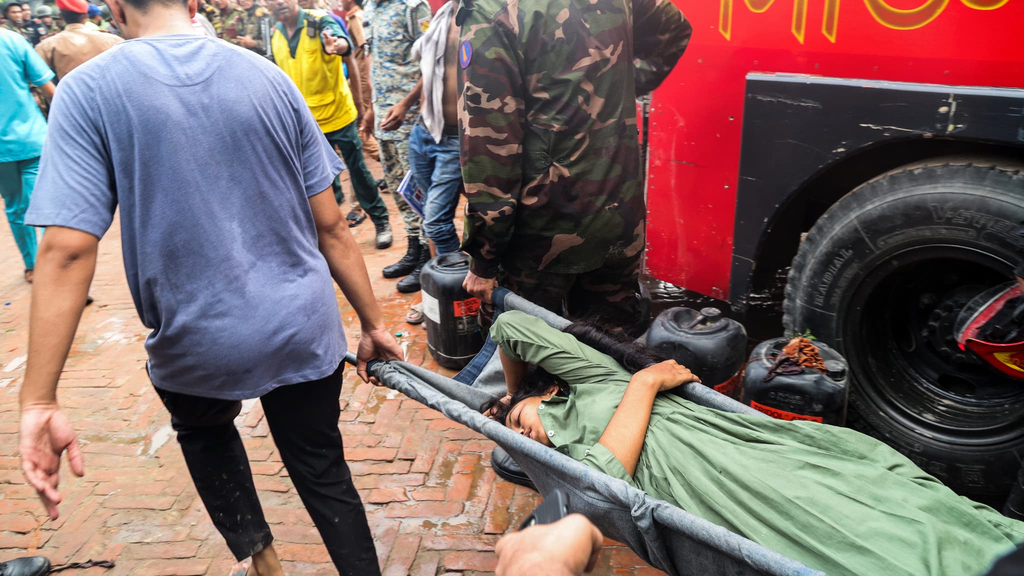 Le personnel de sécurité et de secours transporte une victime blessée vers une ambulance lors d'une opération de recherche et de sauvetage à Dacca, le 21 juillet 2025. Le personnel de sécurité et de secours transporte une victime blessée vers une ambulance lors d'une opération de recherche et de sauvetage à Dacca, le 21 juillet 2025.