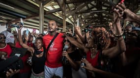 Rodrigue Petitot, président du RPPRAC (Rassemblement pour la protection des peuples et des ressources afro-caribéennes), entouré d'Aude Goussardet Gwladys Roger respectivement secrétaire et trésorière du RPPRAC, lors d'un rassemblement  pour lutter contre la vie chère, à Fort-de-France, en Martinique, le 19 octobre 2024.