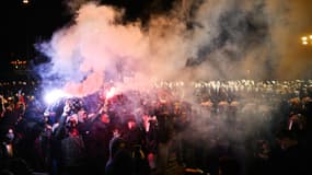 Des manifestants brandissent des fusées rouges devant des policiers anti-émeutes turcs près de l'hôtel de ville d'Istanbul lors d'un rassemblement de soutien au maire arrêté d'Istanbul (Turquie), le 24 mars 2025.