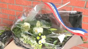 Une gerbe de fleurs déposée devant le commissariat de Roubaix, le 21 mai 2023 