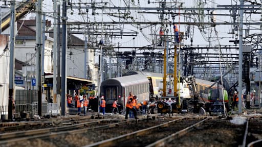 Une grue a permis le levage d'une première voiture du train qui a déraillé, ce vendredi, à Brétigny-sur-Orge le 13 juillet 2013.