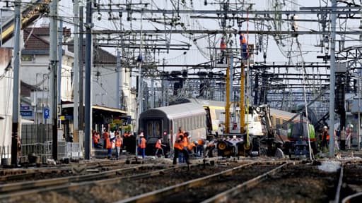 Une grue a permis le levage d'une première voiture du train qui a déraillé, ce vendredi, à Brétigny-sur-Orge le 13 juillet 2013.