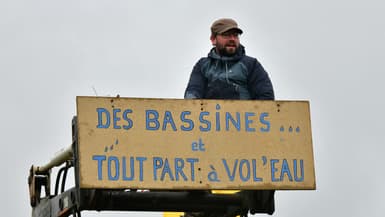 Un manifestant tient une pancarte à Sainte-Soline, dans les Deux-Sèvres, le 25 mars 2023.