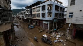 Cette photo prise le 18 juin 2024 montre un homme conduisant dans une rue boueuse à la suite d'inondations causées par de fortes tempêtes à Meizhou, dans la province de Guangdong, dans le sud de la Chine.