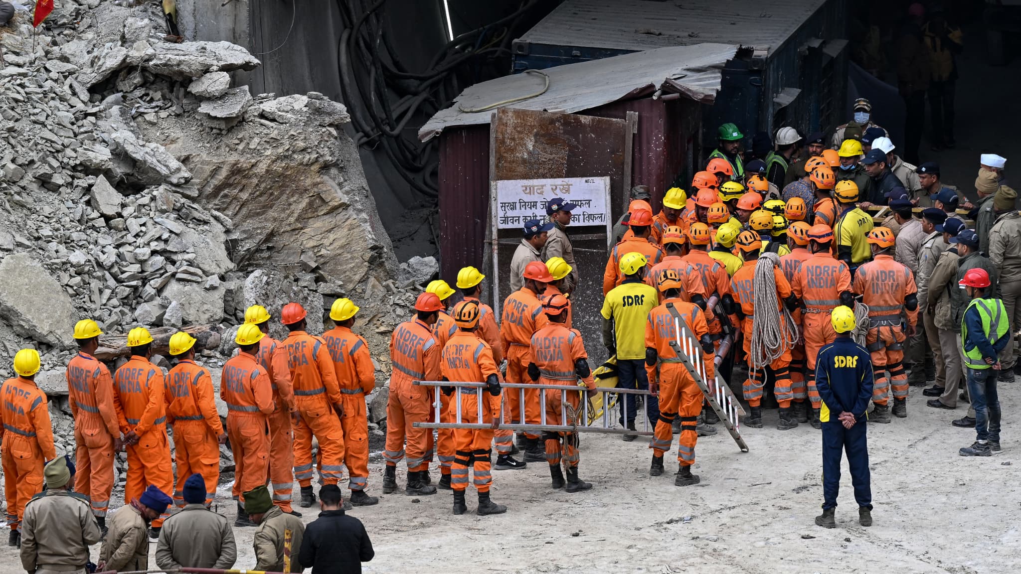 Le personnel de la National Disaster Response Force (NDRF) et d'autres secouristes se rassemblent près du front de taille du tunnel Silkyara, le 28 novembre 2023.