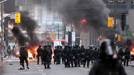 Policiers anti-émeutes déployés dans les rues de Toronto. Des anarchistes vêtus de noir, protestant contre la tenue du sommet du G20 à Toronto, ont endommagé samedi plusieurs devantures de vitrines des rues de la ville canadienne, avant de mettre le feu à
