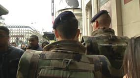 Des soldats participant au plan Vigipirate renforcé patrouillent à proximité des Grands magasins d'un côté.