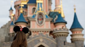 Une visiteuse au parc Disneyland Paris (Marne-la-Vallée) devant le château de la Belle au bois dormant le 16 octobre 2023.