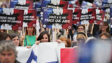 Des manifestants brandissent des pancartes sur lesquelles on peut lire « Violée à 12 ans parce que juive » lors d'une manifestation organisée par des associations, dont SOS Racisme et la Fondation des Femmes, pour dénoncer l'antisémitisme, à Paris, le 20 juin 2024, après le viol collectif antisémite présumé d'une fillette de 12 ans à Courbevoie, en banlieue parisienne.