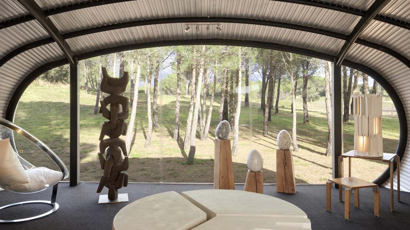 Vue de l'intérieur de la Nova House avec aperçu de la large baie vitrée et de l'ossature en acier.