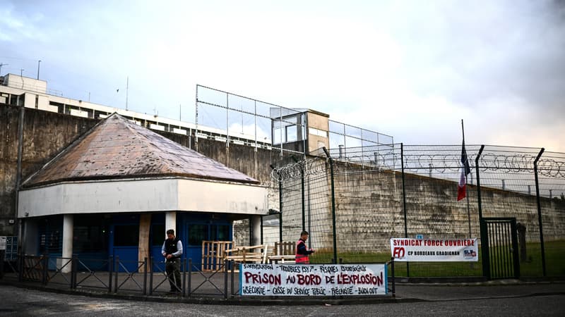 Un gardien de prison allume des bougies à côté d'une banderole sur laquelle on peut lire "La prison au bord de l'explosion" lors d'une manifestation à la prison de Bordeaux-Gradignan, à l'extérieur de Bordeaux, dans le sud-ouest de la France, le 15 mai 2024.