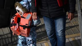 Un enfant migrant secouru après avoir traversé la Manche tient la main d'un adulte à son arrivée à Douvres (Royaume-Uni), le 3 mai 2022 (photo d'illustration).