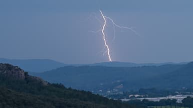 Un éclair frappe une colline au loin lors d'un orage près du Muy, dans le sud de la France, le 12 juin 2023.
