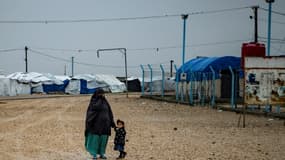 Une femme et une fillette devant le camp Roj dans la nord-est de la Syrie, qui abrite des familles de jihadistes, le 4 mars 2021