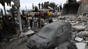 Des riverains observent les dégâts après une frappe israélienne sur le village chiite de Maaysra, au nord de Beyrouth, le 12 octobre 2024;