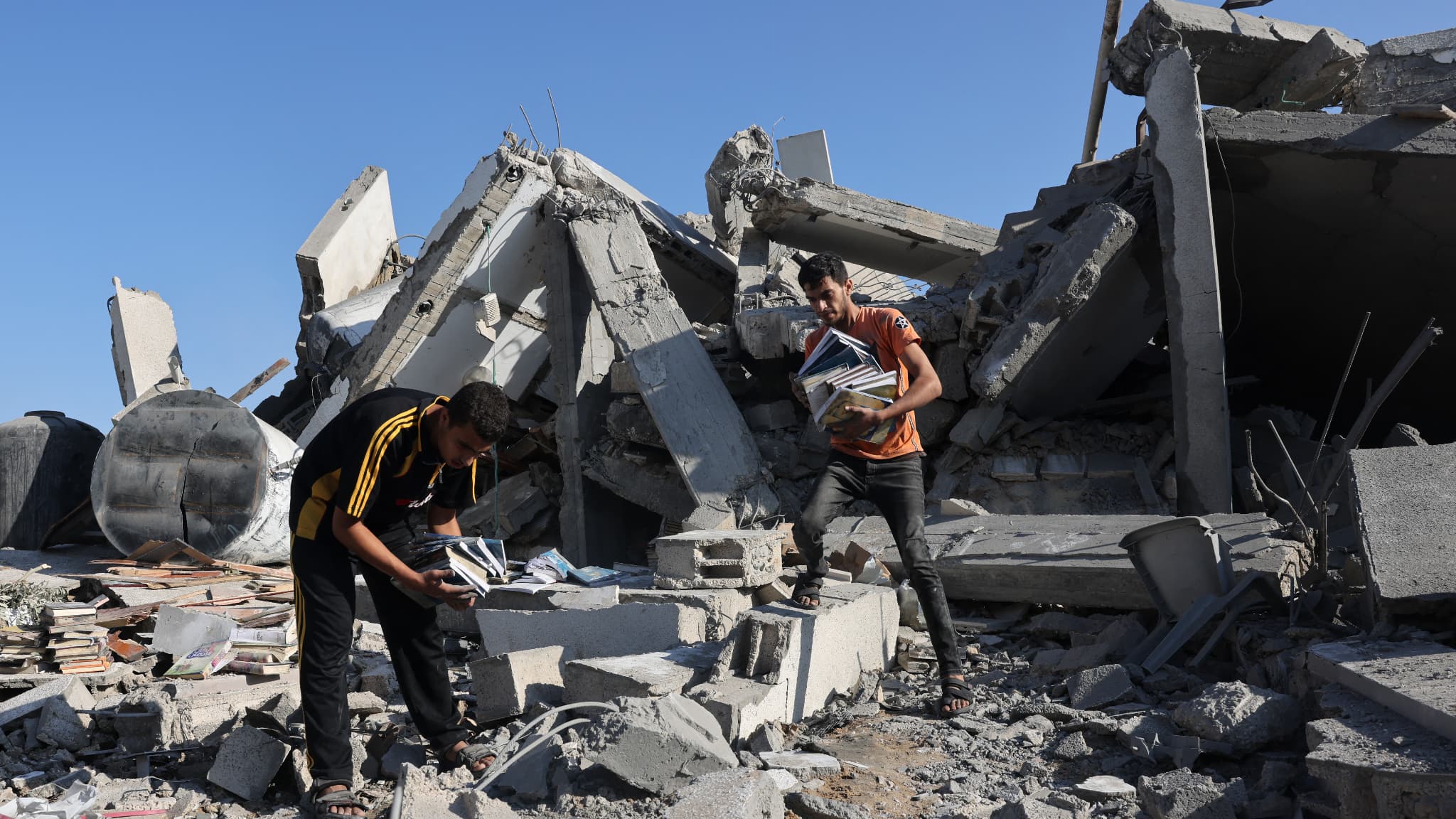 Des Palestiniens récupèrent des livres dans les décombres d'un centre culturel après une frappe israélienne à Rafah, dans le sud de la bande de Gaza, le 18 novembre 2023.