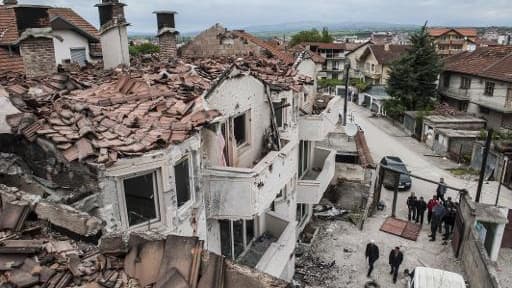 Des habitants dans les ruines de maisons détruites par les combats à Kumanovo, dans le nord de la Macédoine, le 11 mai 2015