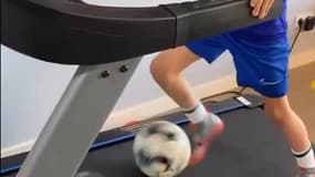 Une jeune footballeur s'entraînant sur un tapis de course