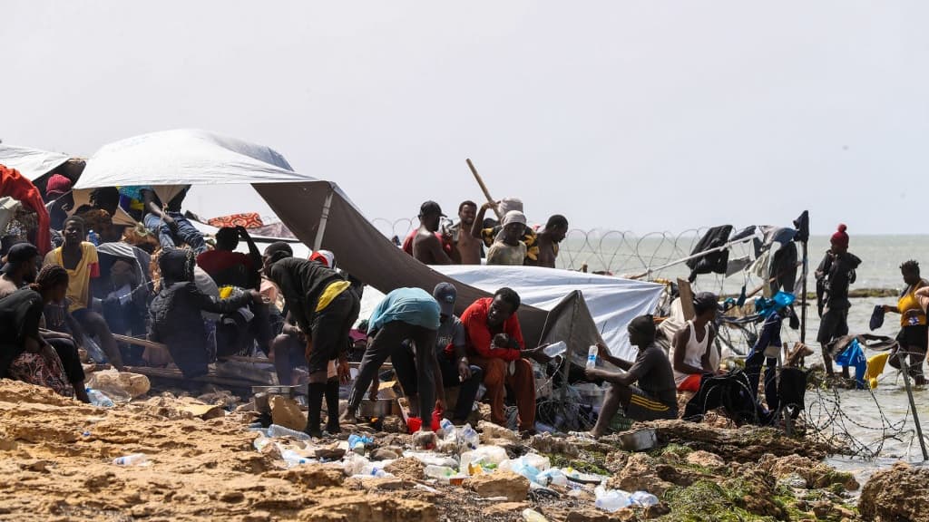 Des migrants subafricains, bloqués sur le bord de mer à la frontière entre la Libye et la Tunisie à Ras Jedir, sur une plage rocheuse le 26 juillet 2023.