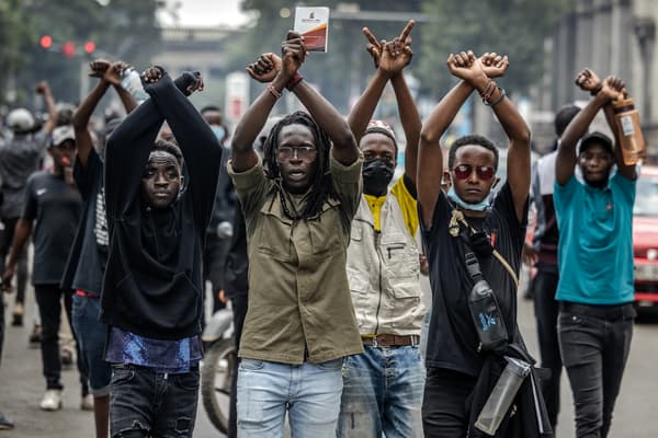 Des manifestants se présentent les poings liés devant des policiers lors de protestations anti-taxes, à Nairobi, au Kenya, le 18 juin 2024