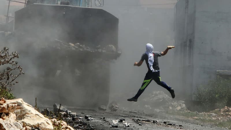 Un Palestinien jette une bouteille contre un blindé de l'armée israélienne, le 24 août 2015.