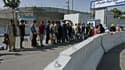 Des Afghans, espérant quitter le pays, font la queue devant l'entrée de l'aéroport de Kaboul, le 29 août 2021